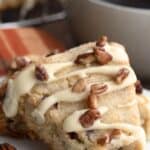 Titled Pinterest image of a keto maple pecan scone on a white plate, with a bite taken out of it.