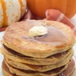 Titled image of a stack of keto pumpkin pancakes with butter and syrup on top.