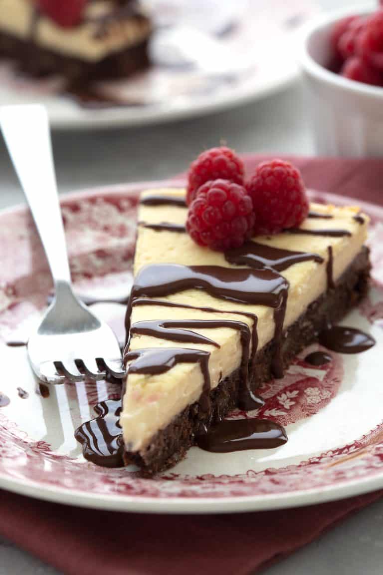 Close up shot of a slice of Keto Brownie Cheesecake on a red patterned plate.