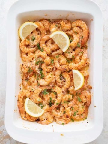 Top down image of Keto Baked Shrimp in a large white baking dish.