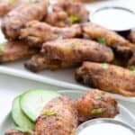 Titled Pinterest image of 3 Cajun Wings on a small plate with a little bowl of ranch dressing.