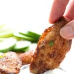 Titled Pinterest image of a hand dipping a Cajun Spice Chicken Wing into a bowl of ranch.