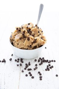 A white bowl filled with keto cookie dough on a white table.