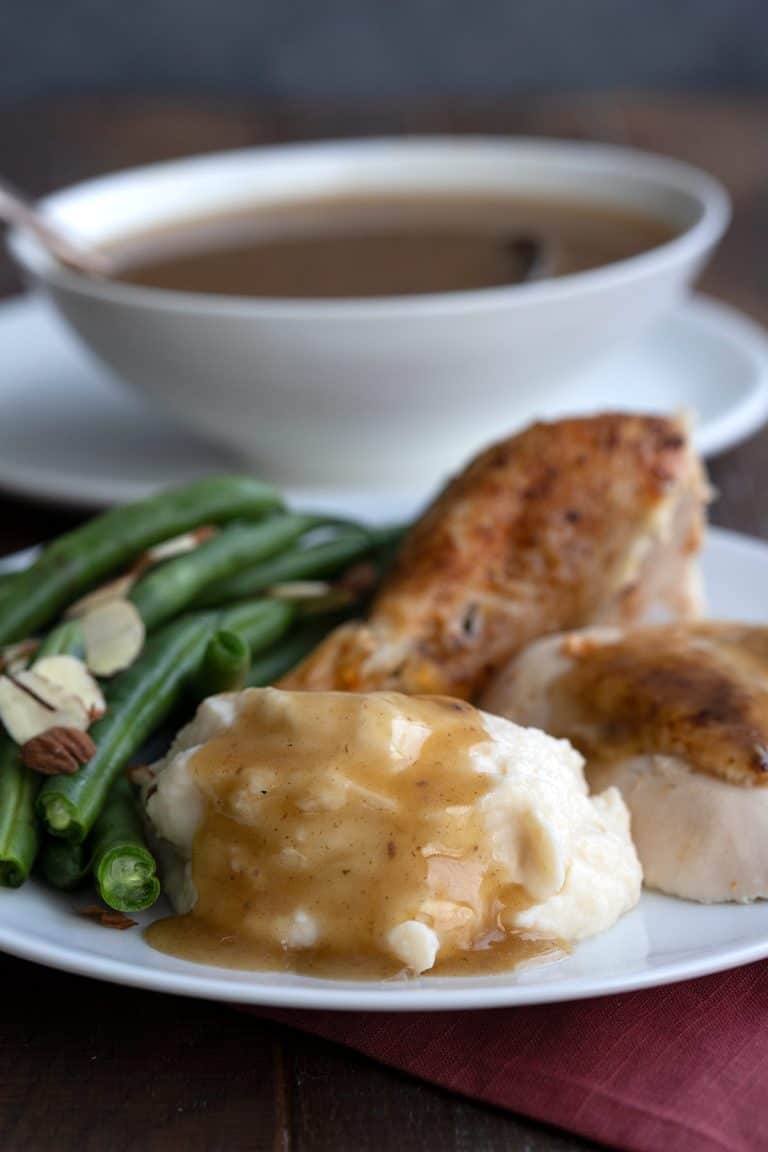 A plate full of roast turkey, green beans, mashed cauliflower and keto gravy.