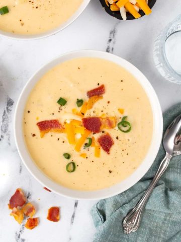 Top down image of keto cauliflower soup in a white bowl.