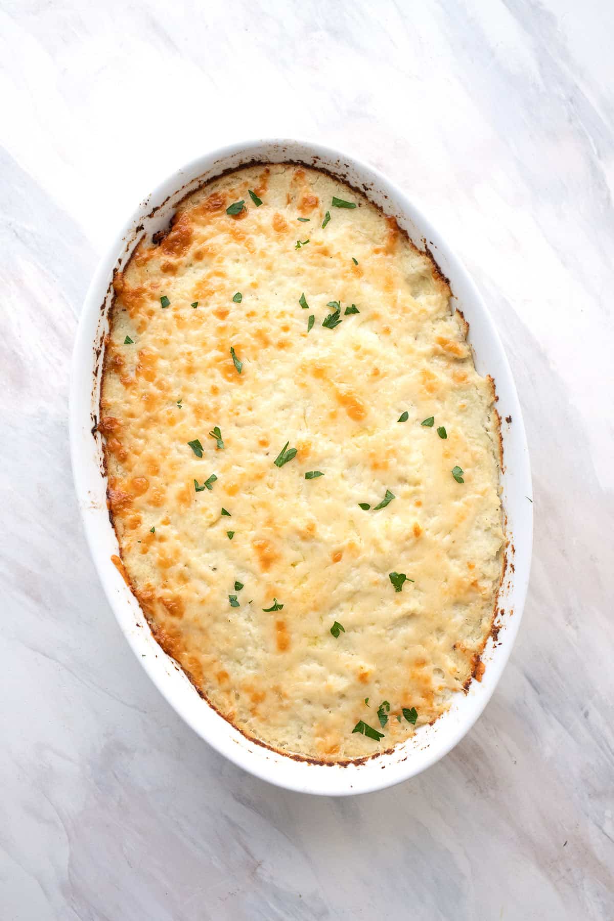 Top down image of Keto Shepherd's Pie in a white oval baking dish.