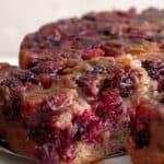 Titled image of a slice of Keto Cranberry Upside Down Cake being removed from the rest of the cake.