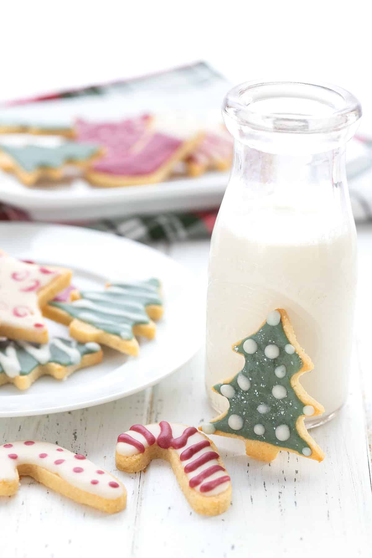 Keto sugar cookies on a table with a glass of milk.