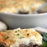Titled image of a serving of Keto Shepherd's Pie with cauliflower topping, on a black plate.