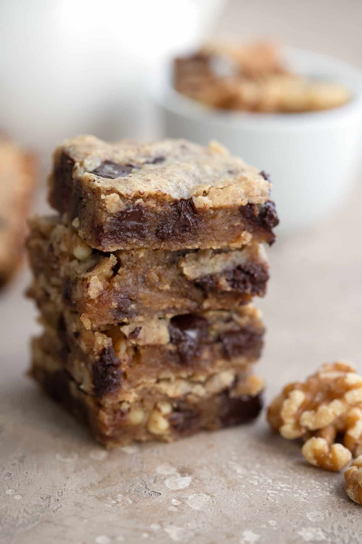 A stack of gooey keto blondies with walnuts.