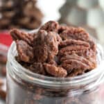 Close up shot of keto candied pecans in a glass jar.