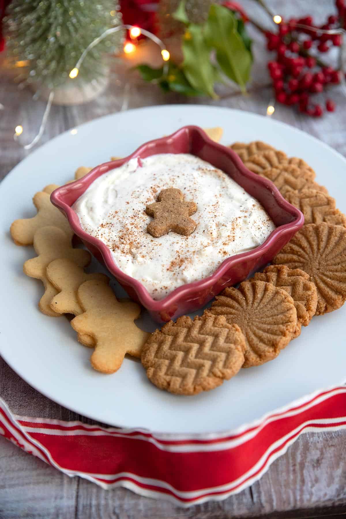 Keto Eggnog Dessert Dip in a red bowl surrounded by keto cookies.