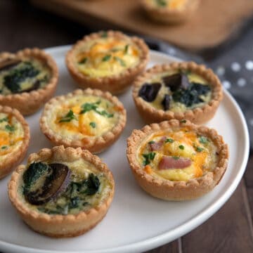 A serving tray filled with two flavors of keto mini quiche.