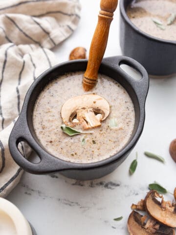 Keto Mushroom Soup in a black bowl with a spoon resting in it.