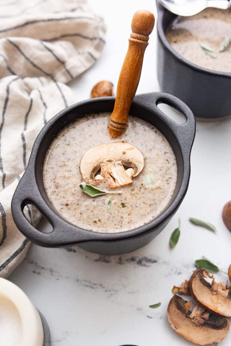 Keto Mushroom Soup in a black bowl with a spoon resting in it.