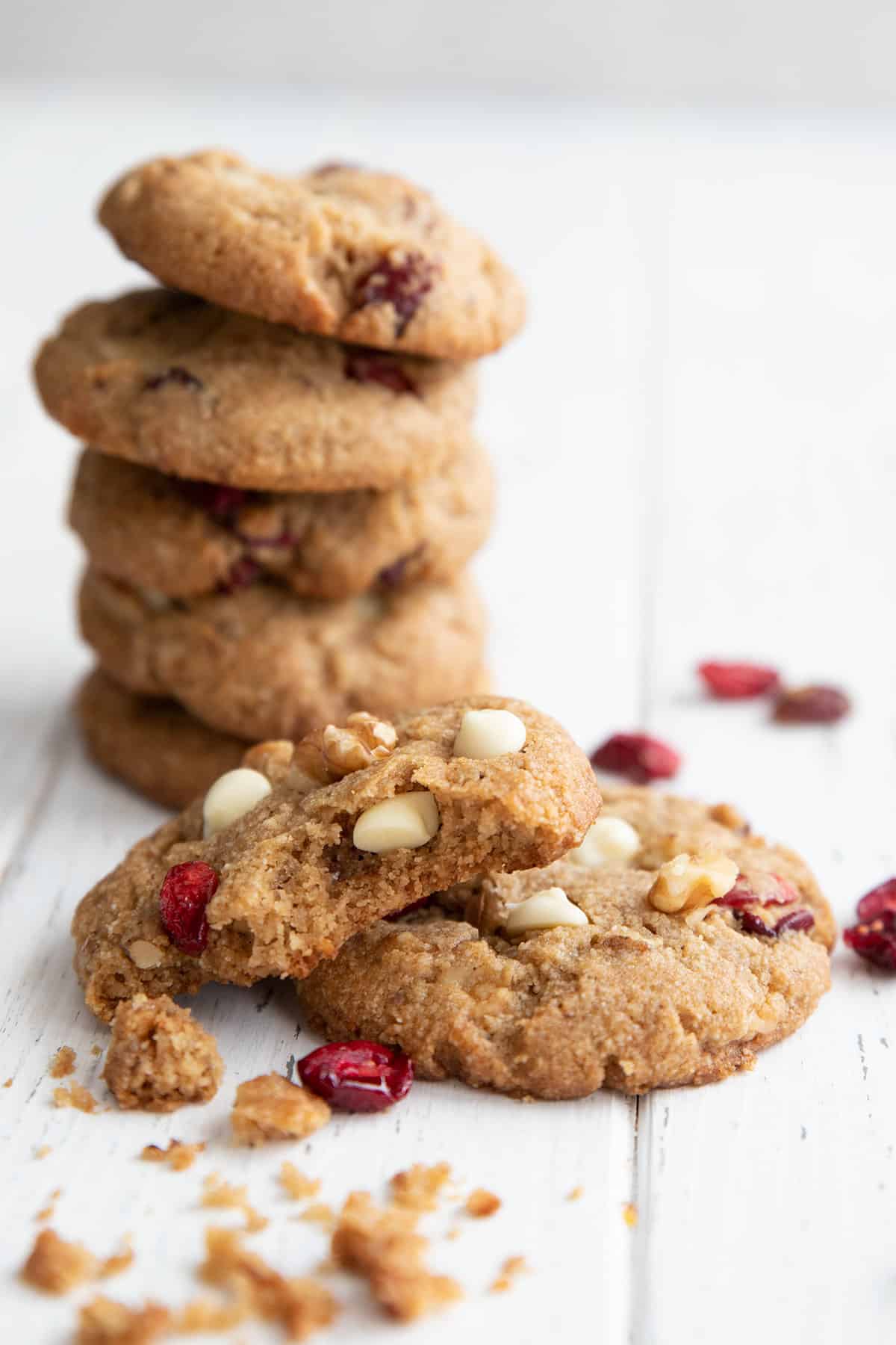 A stack of Keto White Chocolate Cranberry Cookies with one broken open in front.