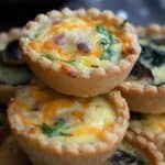 Titled image of a stack of mini keto quiches on a white plate.