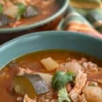 Close up shot of Southwestern Pork Stew in a rustic green bowl.