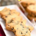 Titled Pinterest image of star-shaped keto shortbread on a rectangular white platter with holiday lights in the background.