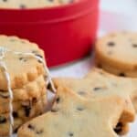 Keto shortbread cookies on a white table, with a tin of more cookies in the background.