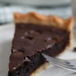 Titled image of a slice of Keto Brownie Pie on a white plate with a fork.