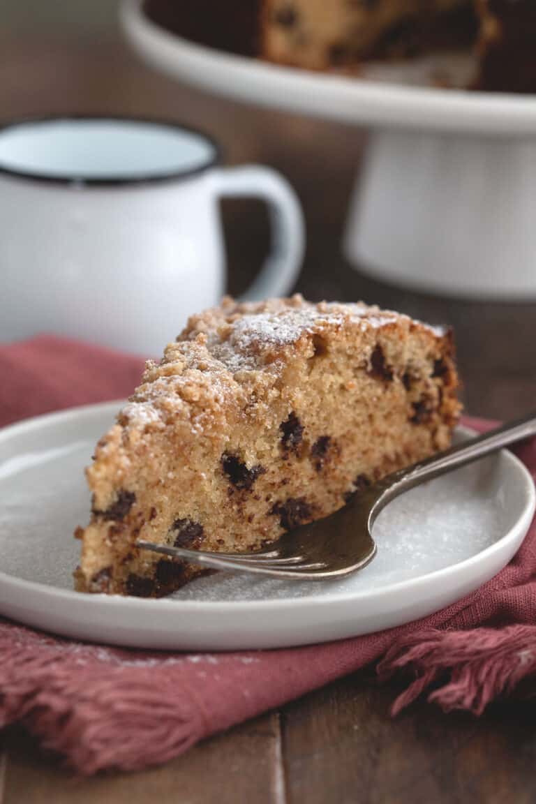 A slice of keto coffee cake on a white plate over a red napkin.