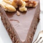 Titled Pinterest image of a slice of keto chocolate walnut torte on a white plate.