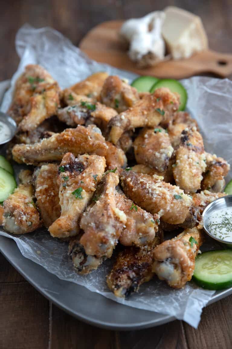 A tray filled with keto chicken wings on a brown wooden table.