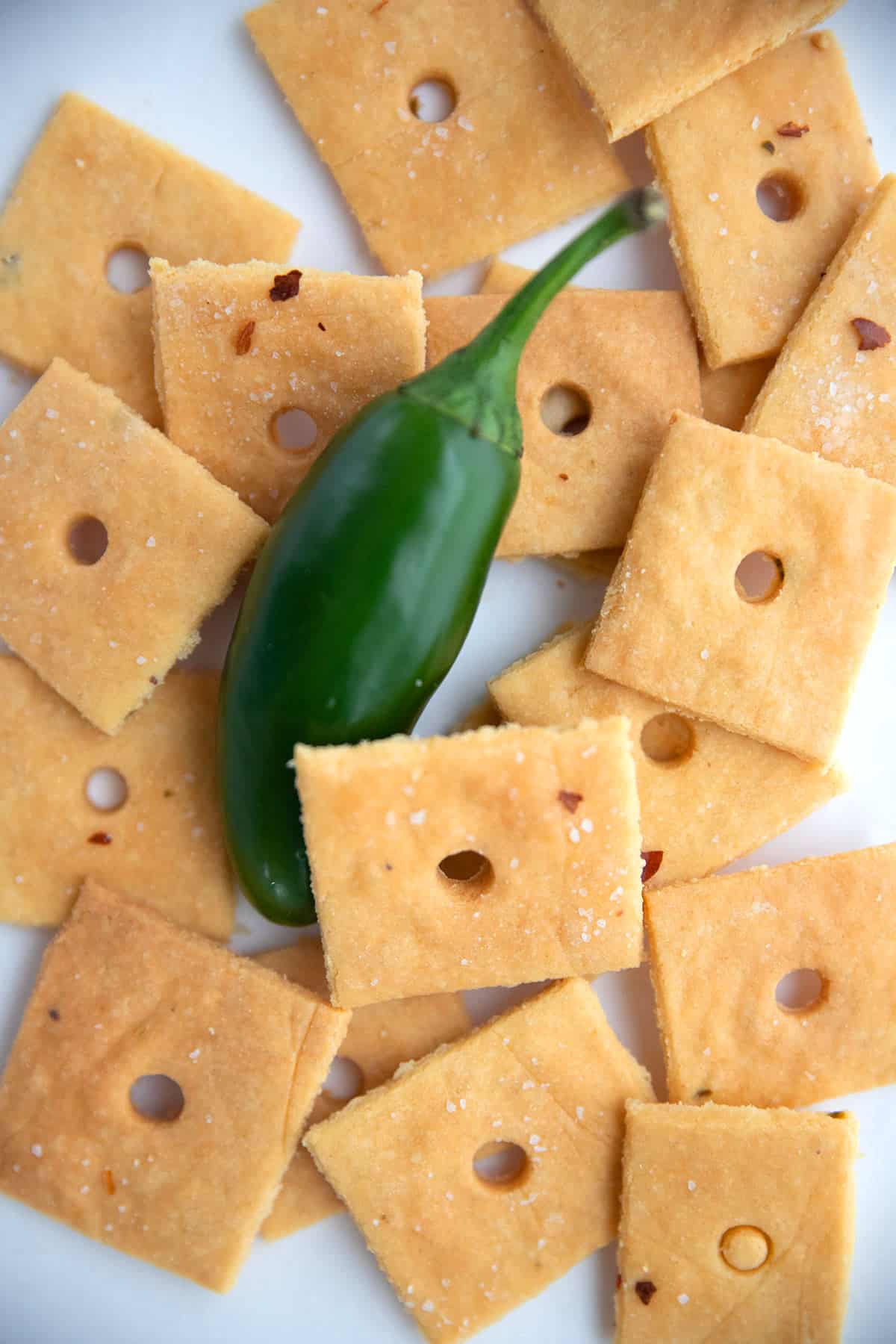Top down image of a pile of keto cheese crackers with a jalapeno.