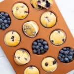 Top down image of almond flour blueberry muffins in a muffin pan.