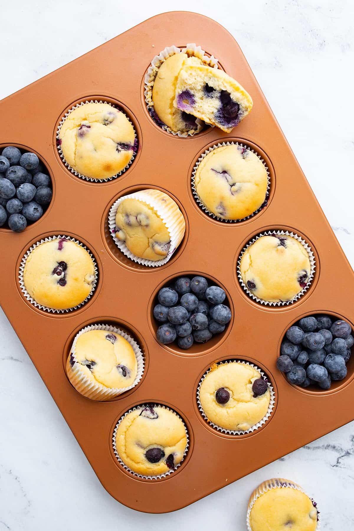 Top down image of almond flour blueberry muffins in a muffin pan.