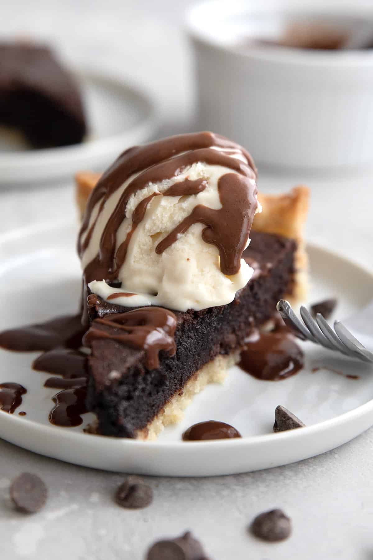 Close up shot of a slice of brownie pie with ice cream on top.