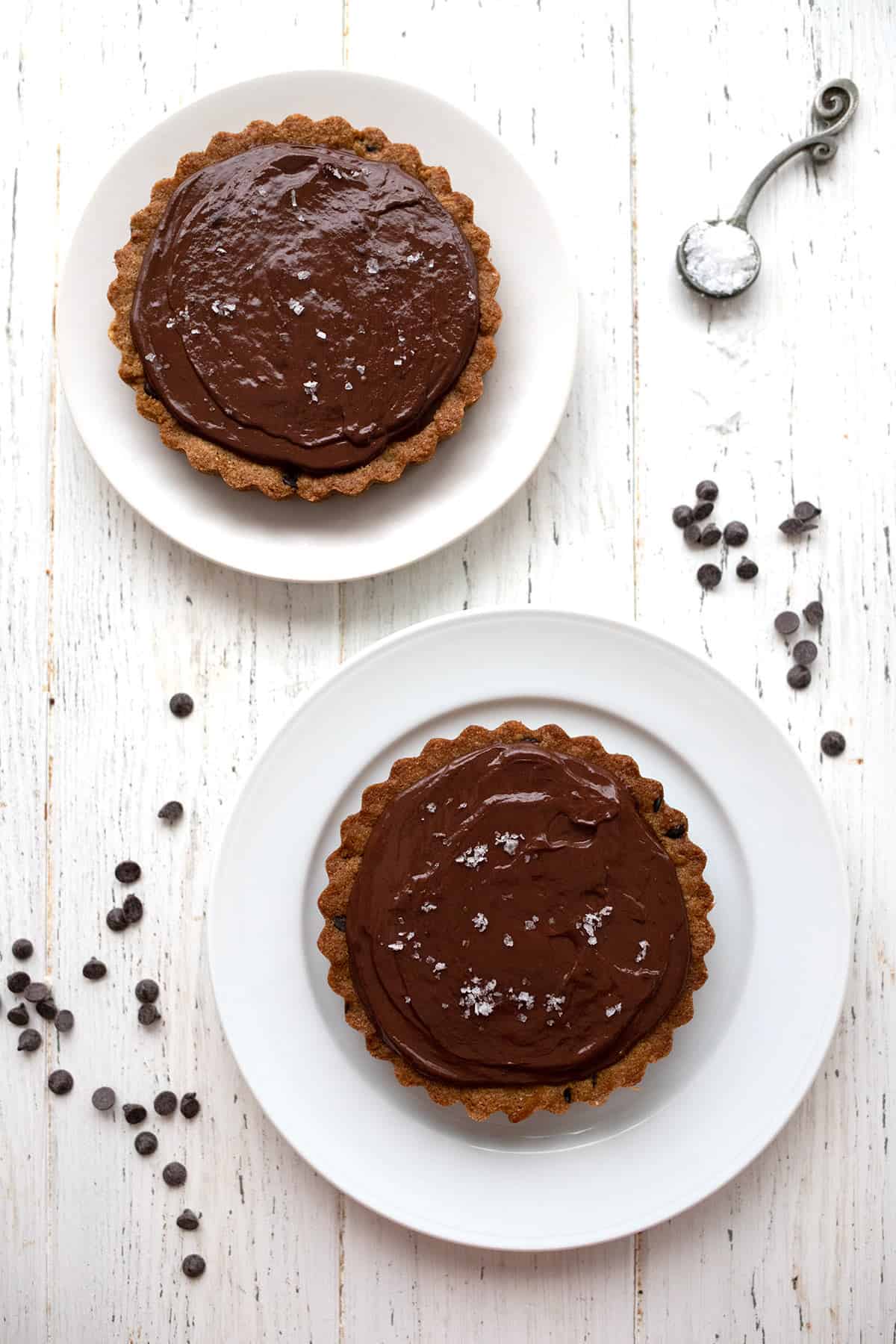 Top down image of two keto caramel tarts with chocolate ganache.