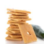 A stack of Keto Cheese Crackers on a white background with a jalapeno.