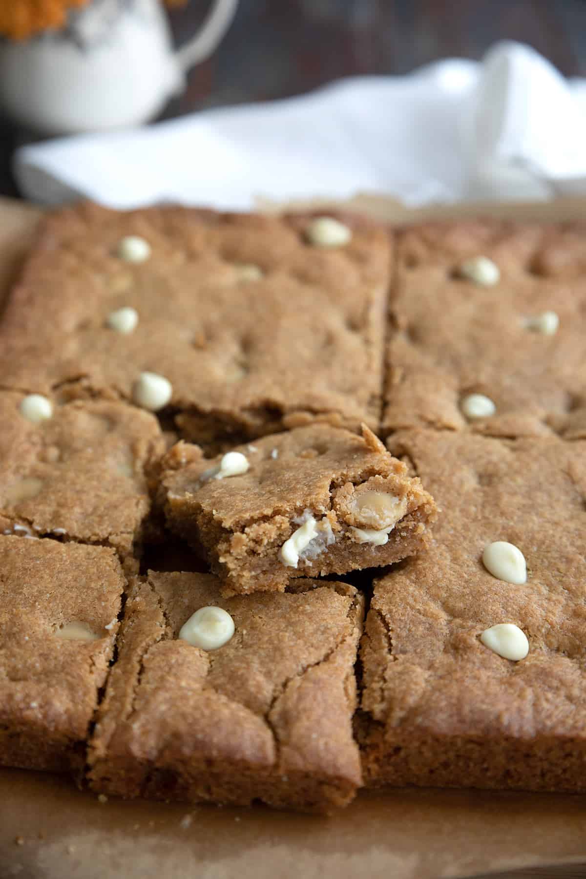 Close up shot of freshly baked Keto Cookie Butter Bars with white chocolate chips.