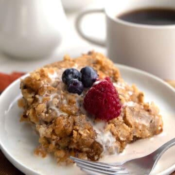 A serving of baked keto oatmeal on a white plate with berries on top.