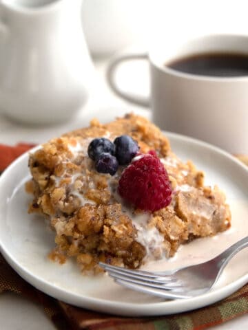 A serving of baked keto oatmeal on a white plate with berries on top.
