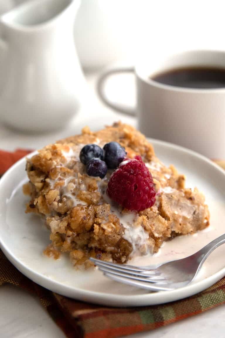 A serving of baked keto oatmeal on a white plate with berries on top.