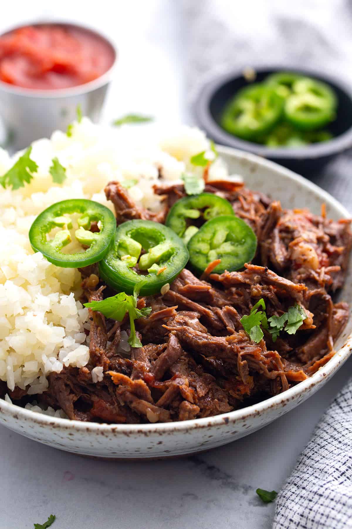 Mexican shredded beef with cauliflower rice, sliced jalapenos, and cilantro.