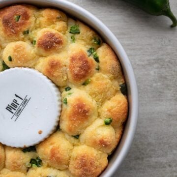 Top down image of savory keto monkey bread in the pan with a jalapeno next to it.
