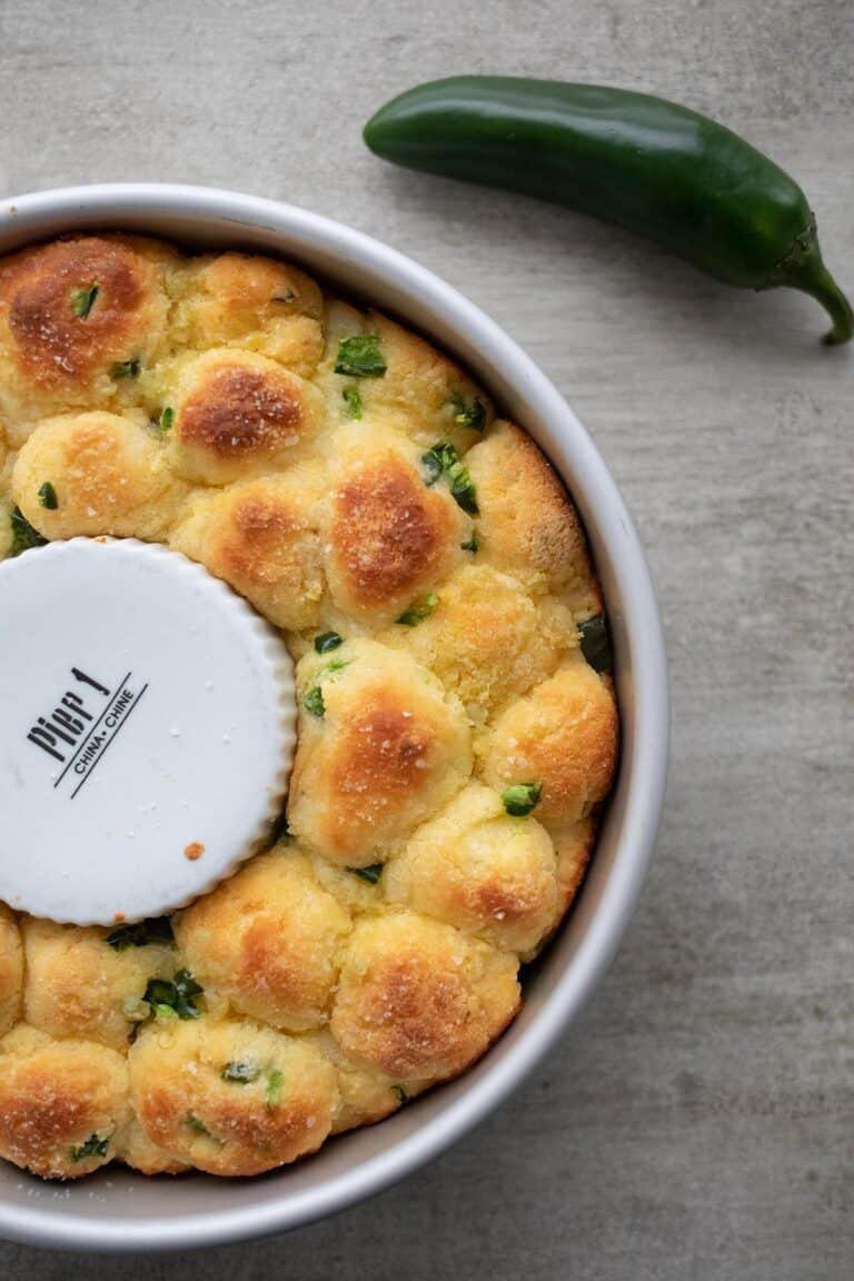 Top down image of savory keto monkey bread in the pan with a jalapeno next to it.