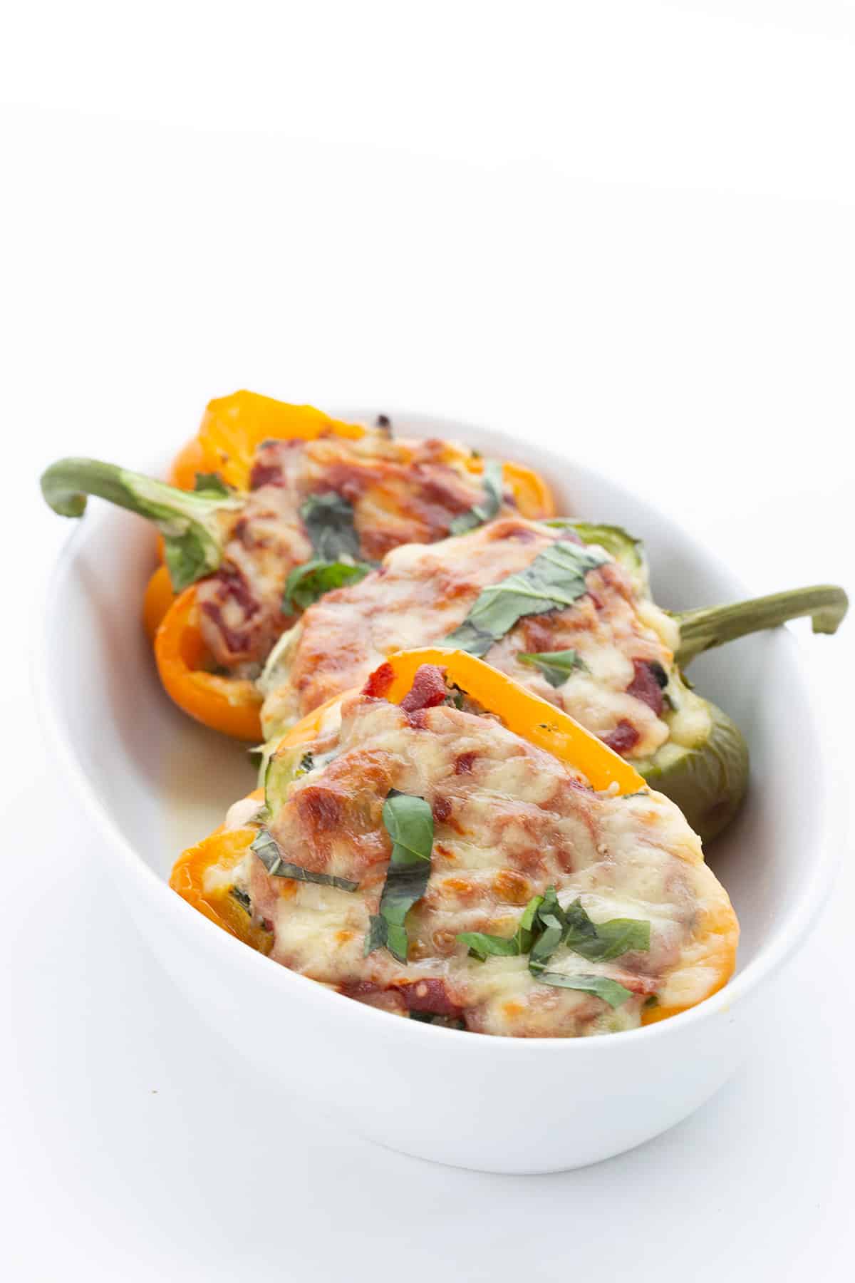 Keto stuffed peppers in a white ceramic baking dish.