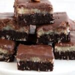 A stack of keto almond joy brownies on a white cake stand with the title across the top.