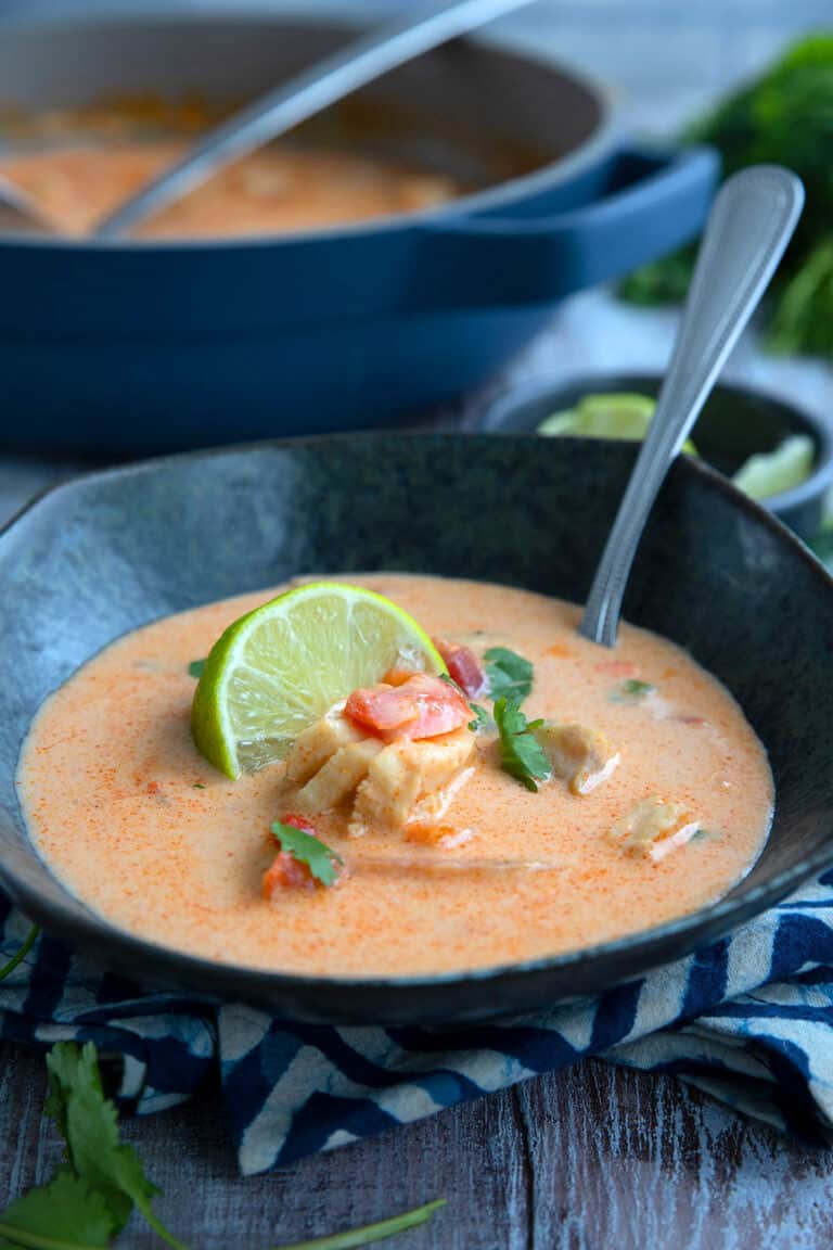 A black bowl filled of Brazilian Fish Stew on a wooden table.