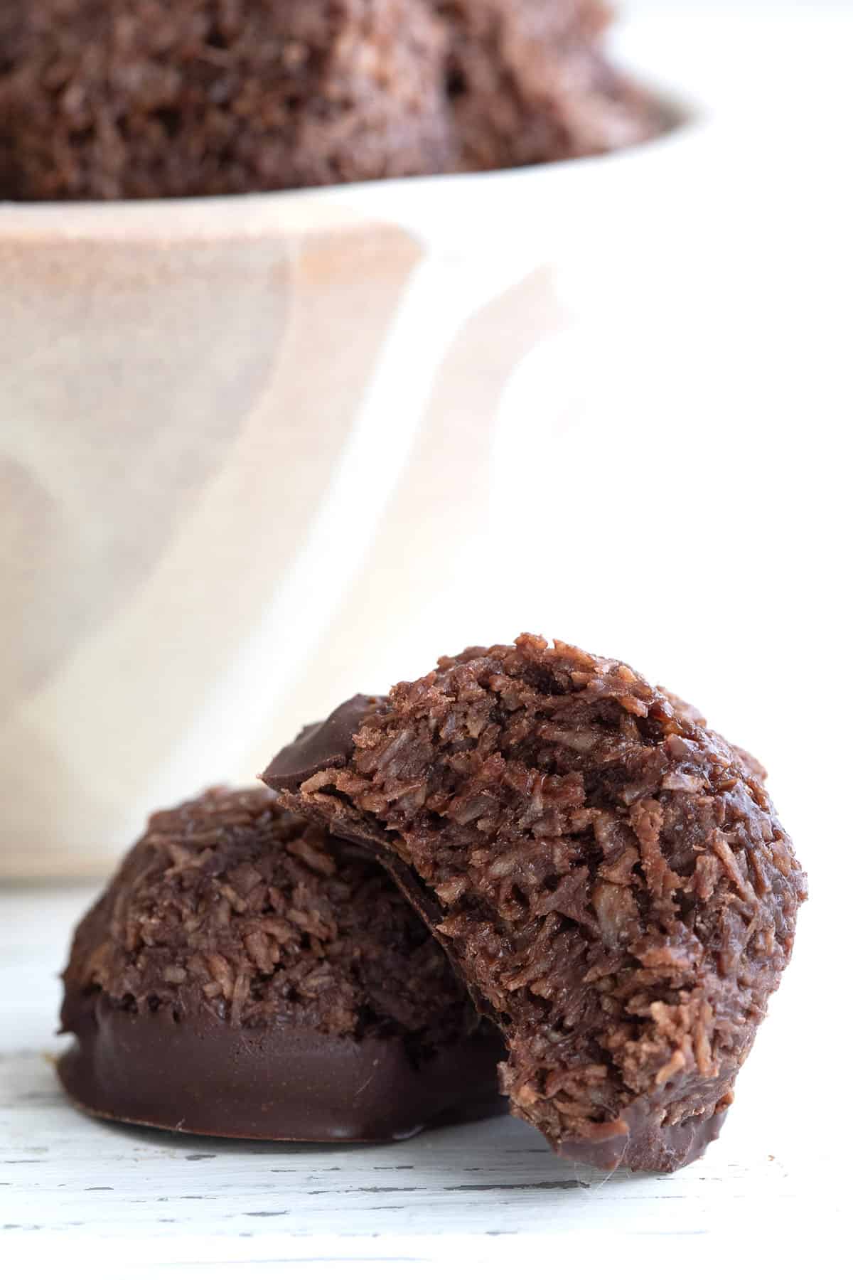 Close up shot of two no bake chocolate macaroons with a bite taken out of one.