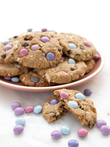 A pink plate full of Keto Cookies with candy pieces.