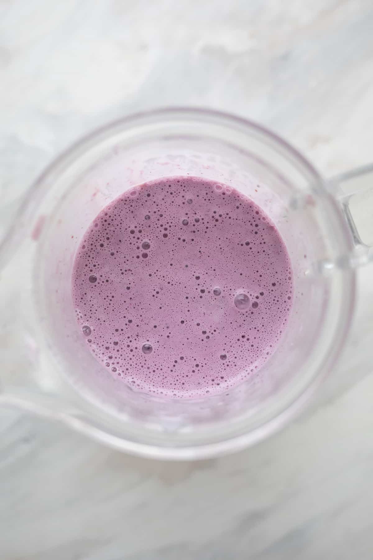 Top down image of keto blueberry smoothie in the blender.