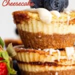 Titled Pinterest image of Keto Cinnamon Roll Cheesecakes in a stack with blueberries on top.
