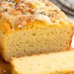 Titled image of a loaf of Keto Coconut Flour Bread on a cutting board with a slice cut out in front.