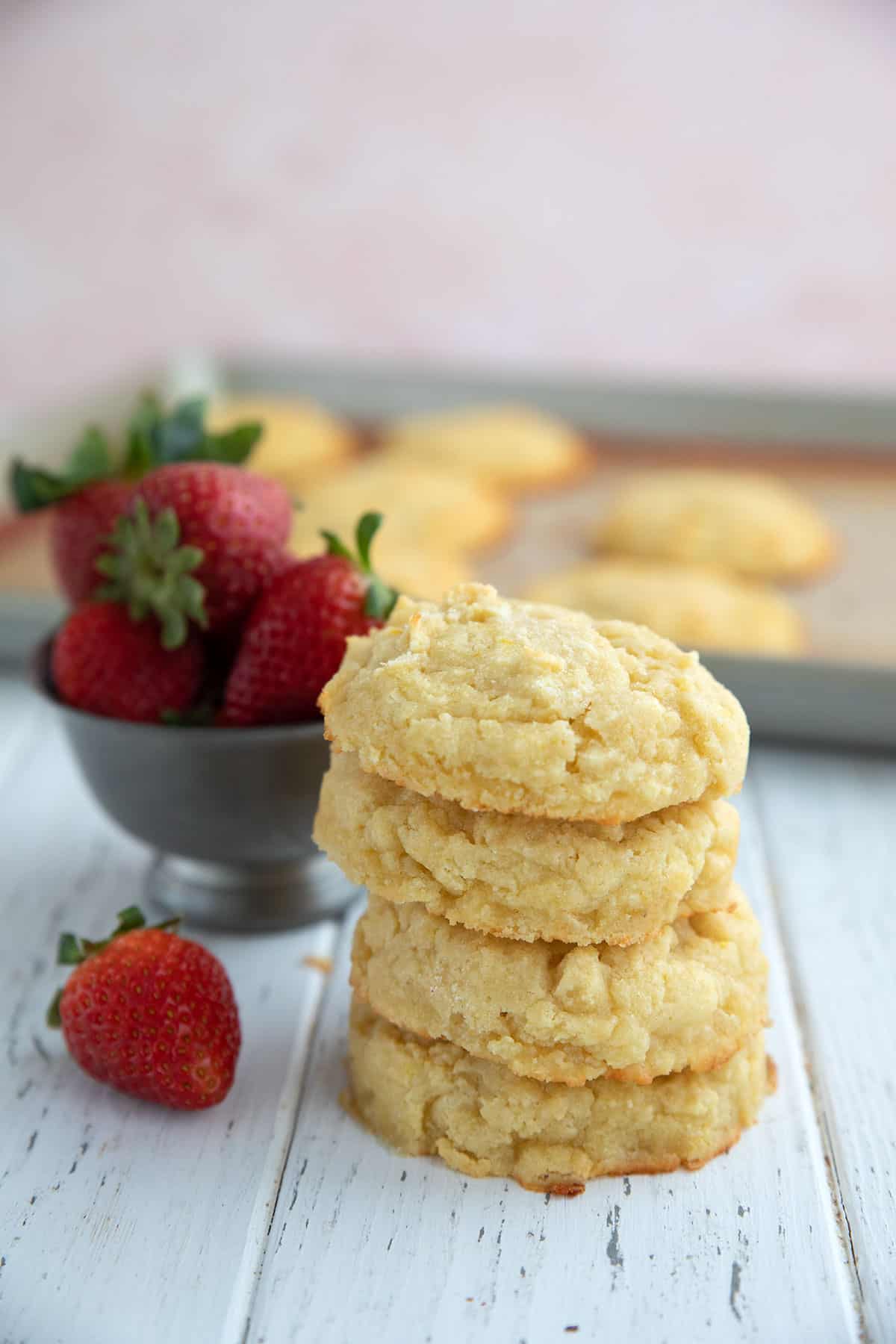 Sweet keto biscuits in a stack on a white wooden table, ready to make strawberry shortcake.